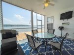 SCREENED PATIO WITH AN EXIT DOOR, TV, TABLE, CHAIRS & GAS GRILL